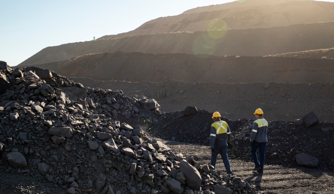 south32 workers walking through dirt and rocks